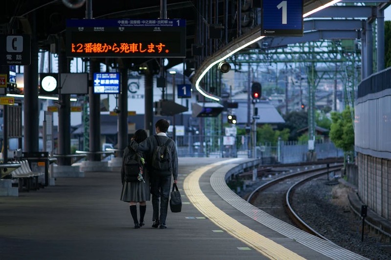 Couple walking arm in arm at Uji train station platform in Kyoto, Japan.
