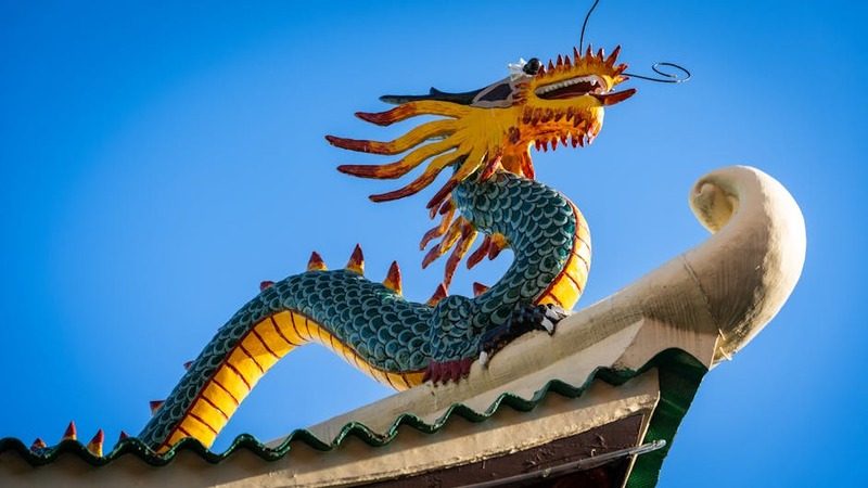 Arte promocional de O Legado do Dragão Esquecido, mostrando um dragão ancestral e um jovem herói.