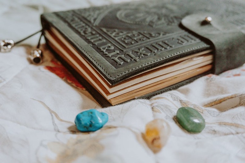 Uma jovem alquimista em um laboratório real, com um livro antigo e poções coloridas.