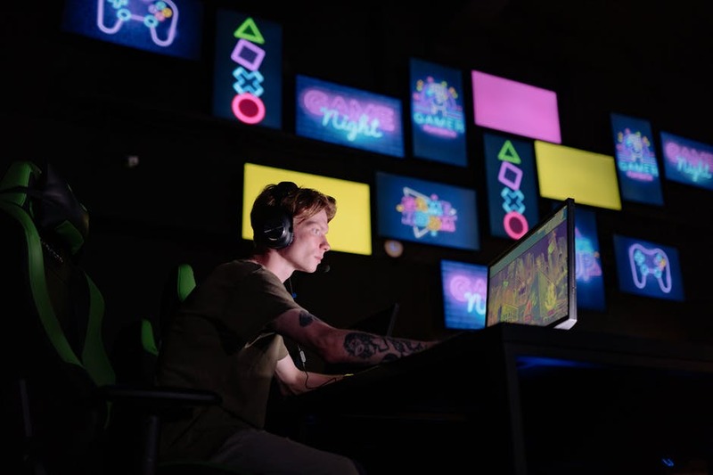 Um gamer com fones de ouvido em um ambiente escuro, imerso em um jogo narrativo