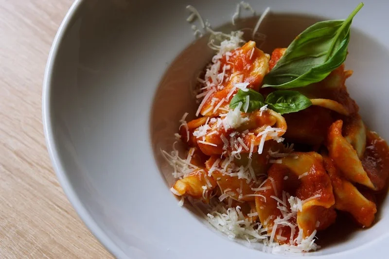 Prato de massa caseira com molho de tomate rico e manjericão