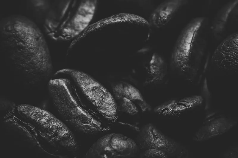Diferentes tipos de grãos de café torrados, mostrando torra clara, média e escura