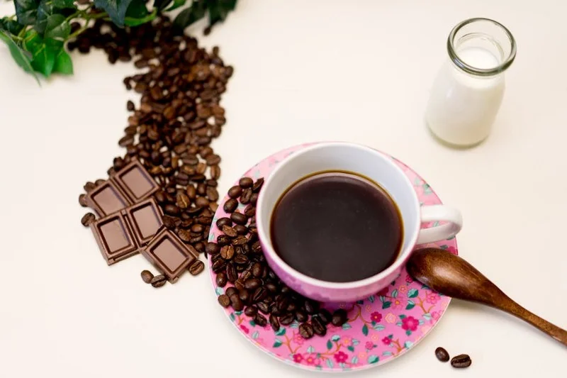 Diferentes tipos de leite e grãos de café sobre uma mesa de madeira
