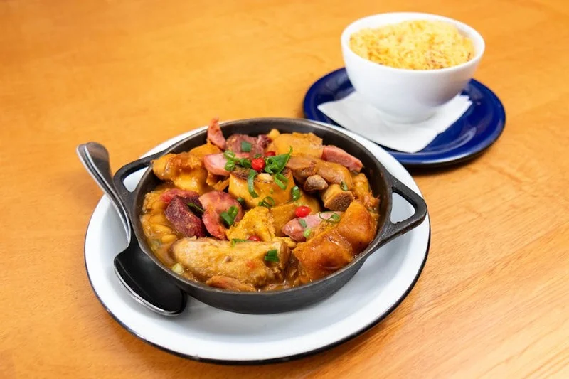 Feijoada brasileira tradicional com arroz, farofa e couve