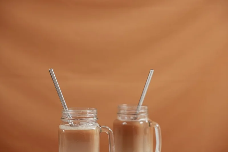 Variedade de cafés gelados com diferentes coberturas e canudos reutilizáveis